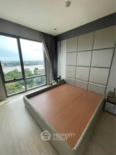 Modern bedroom with large window offering stunning river view and stylish decor.
