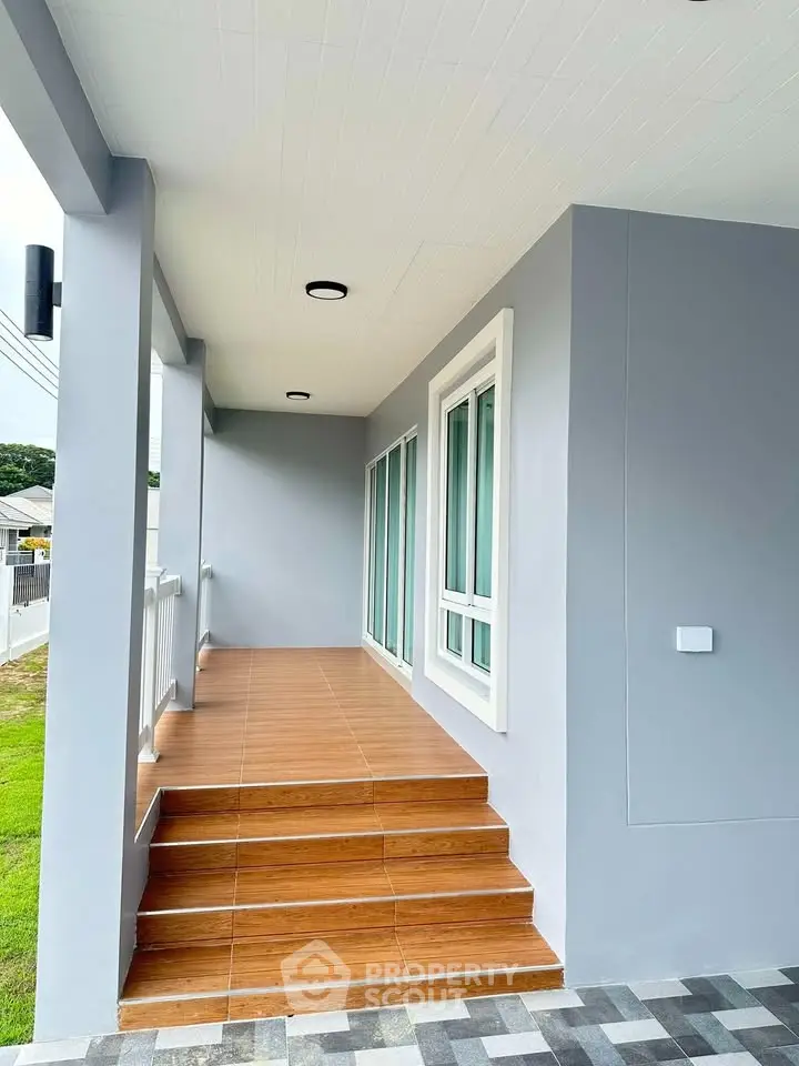 Modern exterior with sleek design and wooden steps leading to a stylish entrance.
