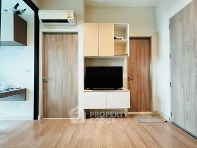 Modern living room with wooden flooring and sleek TV unit