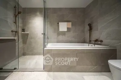 Luxurious modern bathroom with elegant bathtub and glass shower enclosure.