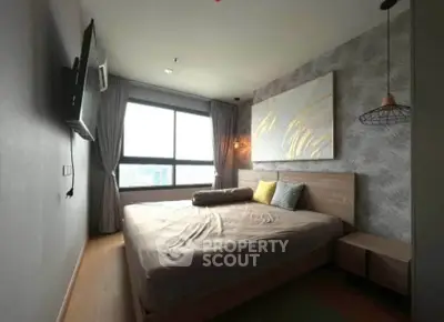 Modern bedroom with stylish decor and large window offering natural light.