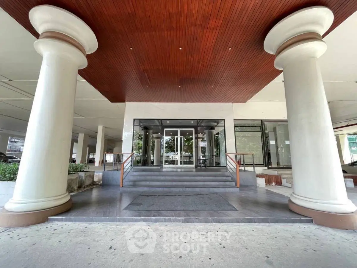 Grand entrance with impressive columns and modern glass doors