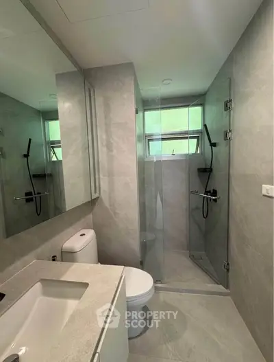 Modern bathroom with sleek design, glass shower, and elegant fixtures in a contemporary home.