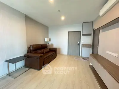 Spacious living room with modern leather sofa and sleek wooden flooring