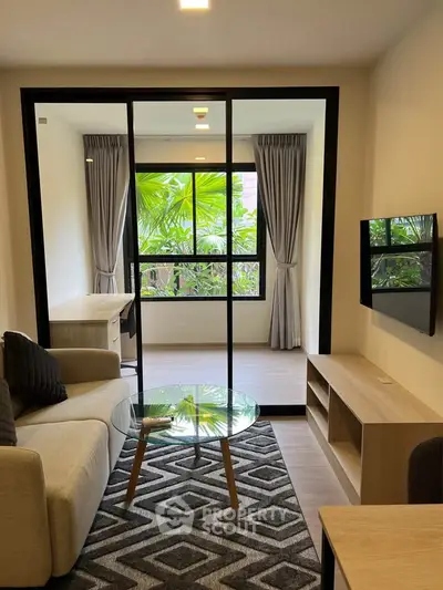 Modern living room with glass partition and lush garden view, featuring cozy sofa and stylish decor.