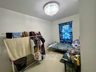 Cozy bedroom with clothes rack and colorful decor, perfect for personalizing your space.