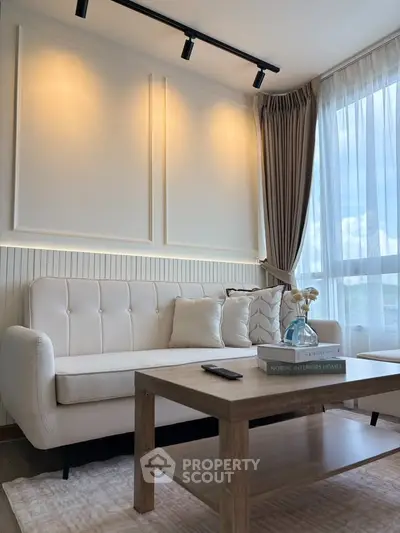 Elegant living room with modern decor and natural light, featuring a cozy sofa and stylish coffee table.