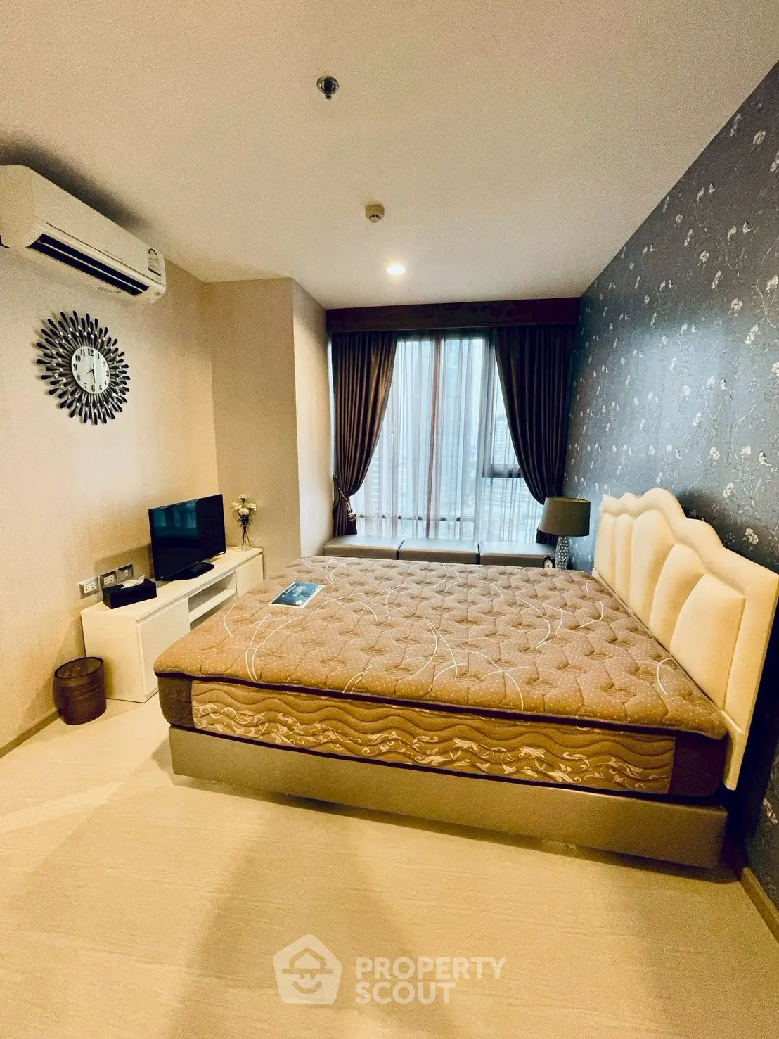 Spacious bedroom with modern decor and large window for natural light.