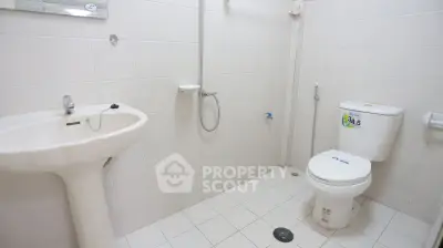 Spacious bathroom with modern fixtures and tiled walls in a real estate property.