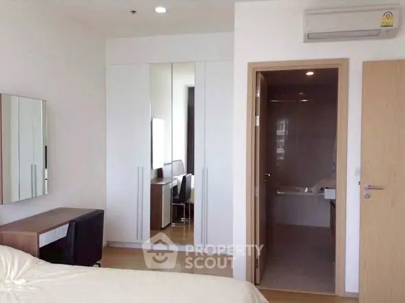 Modern bedroom with ensuite bathroom and sleek furniture design.