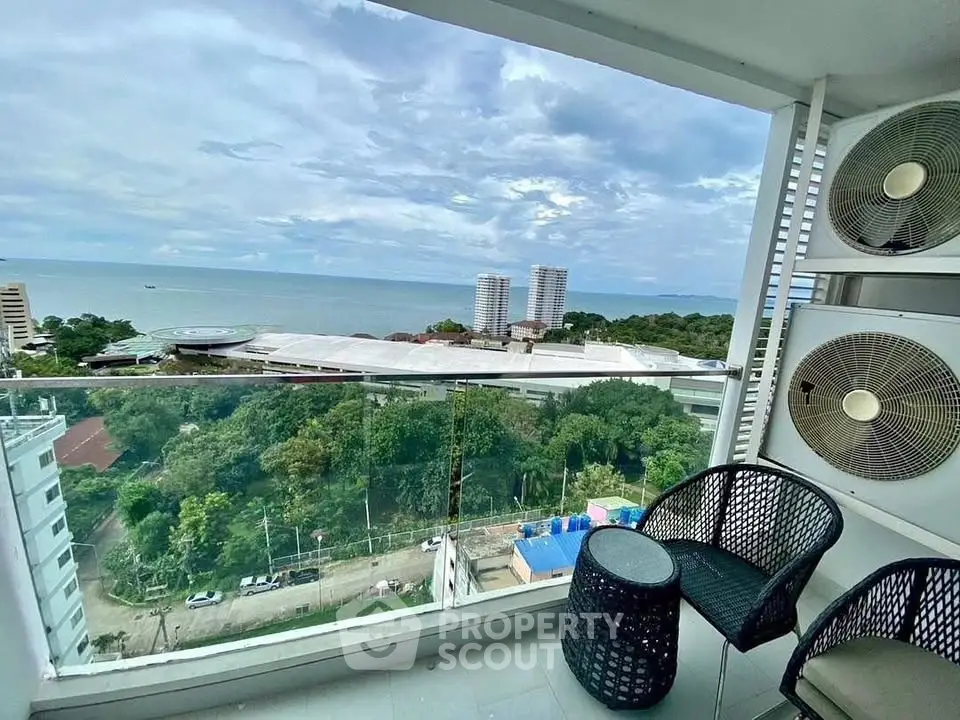 Stunning balcony view of ocean and cityscape from high-rise apartment, perfect for relaxation.