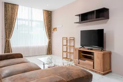 Spacious living room with modern furniture and large window for natural light.