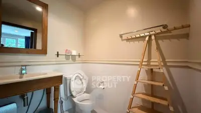 Cozy bathroom with wooden accents and ladder-style towel rack