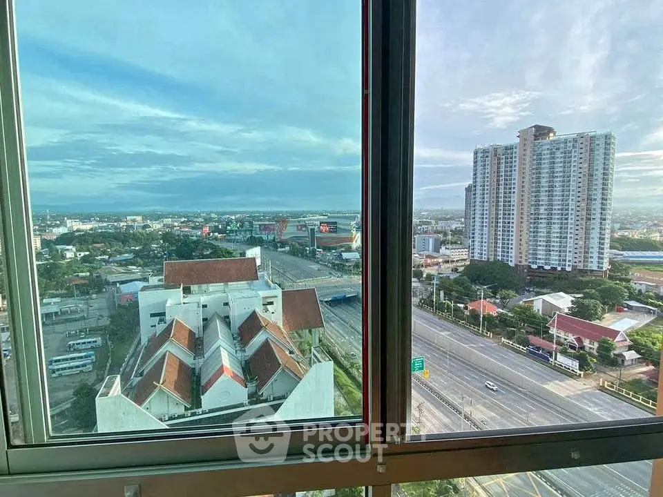 Stunning cityscape view from high-rise apartment window, showcasing urban skyline and distant horizon.