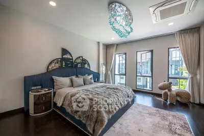 Luxurious bedroom with elegant decor and large windows offering natural light.