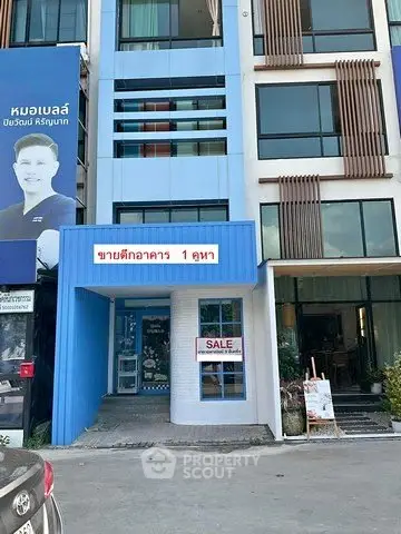 Modern building exterior with sale sign, ideal for investment opportunity.