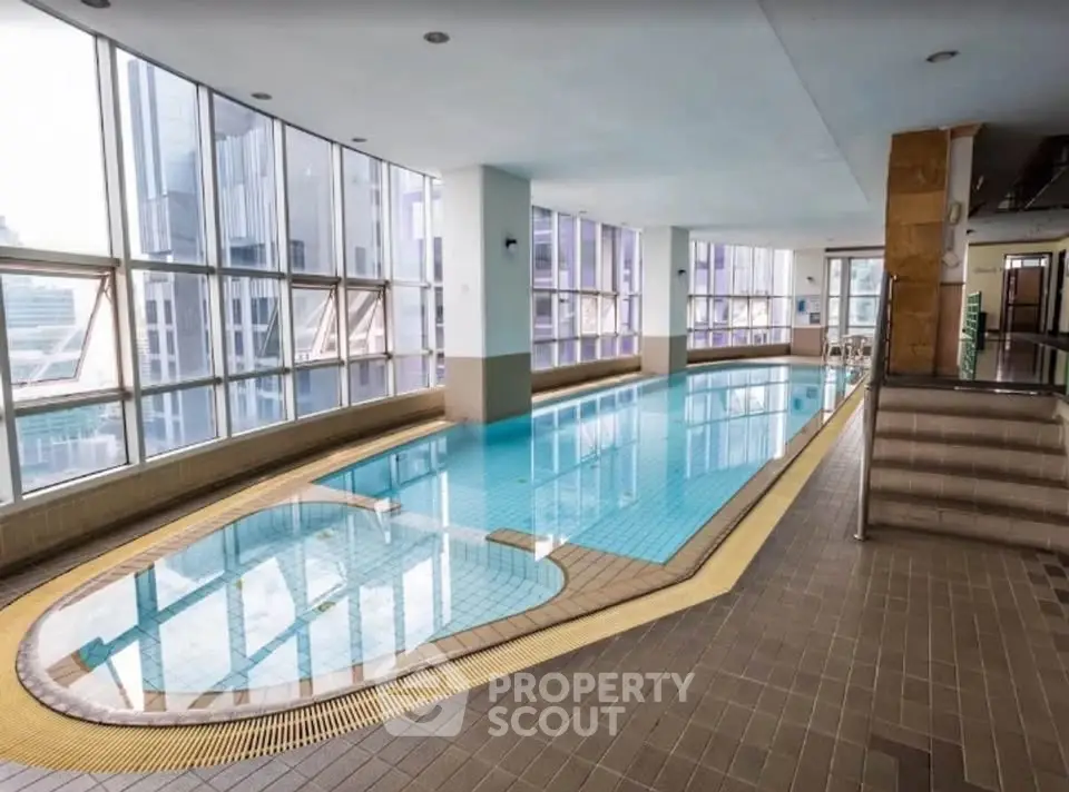 Luxurious indoor pool with city view in modern high-rise building