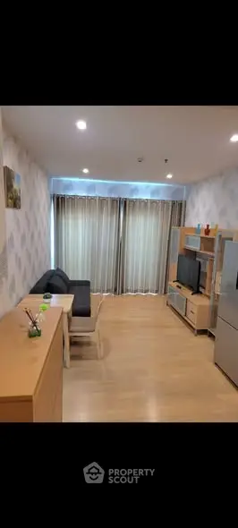 Modern living room with sleek furniture and large window, perfect for cozy relaxation.