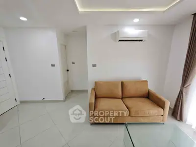 Modern living room with beige sofa and air conditioning unit