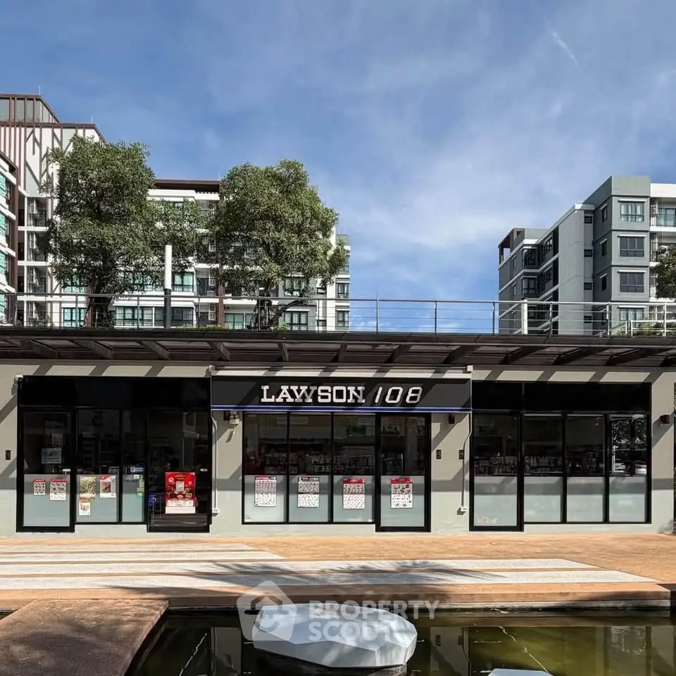 Modern apartment complex with retail space and landscaped surroundings.