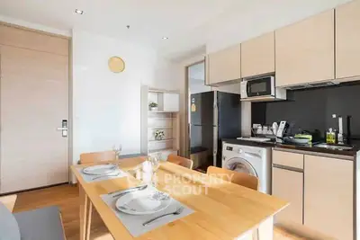 Modern kitchen with dining area, featuring sleek appliances and wooden cabinetry.