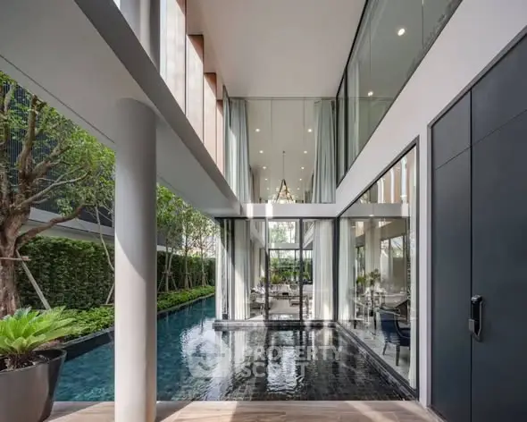 Luxurious modern home with stunning poolside view and high ceilings, showcasing elegant architecture and serene outdoor space.