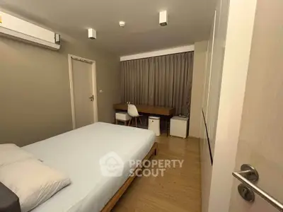 Modern bedroom with minimalist design, featuring a comfortable bed, study desk, and ample natural light.