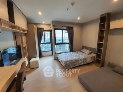 Modern bedroom with city view, featuring stylish furniture and ample natural light.