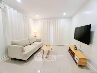 Modern living room with sleek furniture and wall-mounted TV