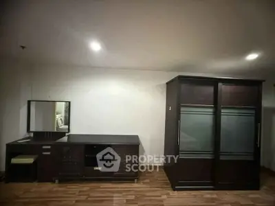 Spacious bedroom with modern dark wood furniture and elegant flooring
