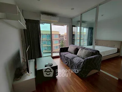 Modern living room with cozy sofa and large window view in stylish apartment.