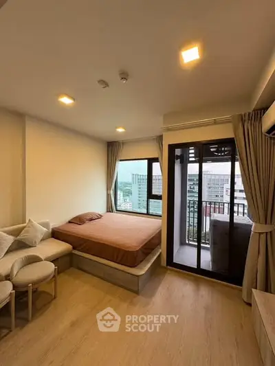 Modern studio apartment with cozy bed and city view balcony