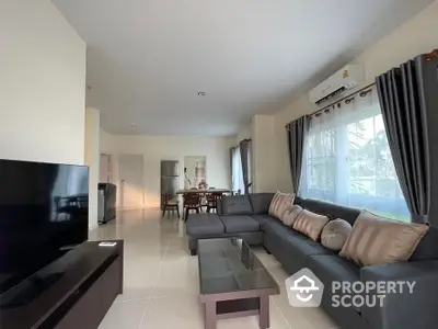 Spacious modern living room with large sofa and dining area, perfect for family gatherings.