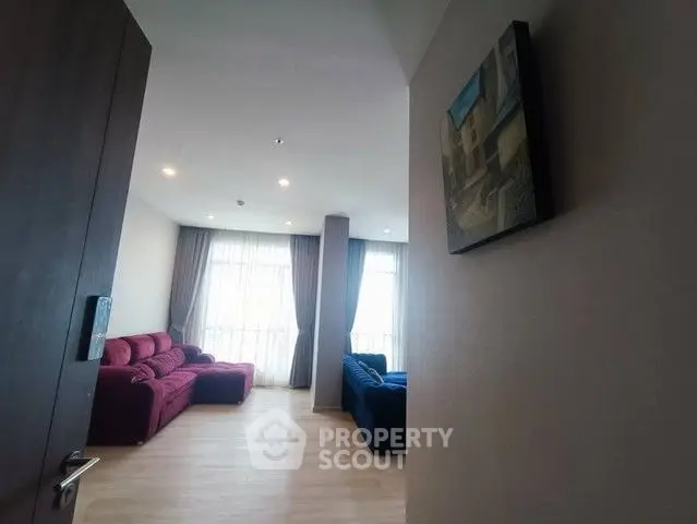 Spacious living room with modern decor and large windows for natural light.