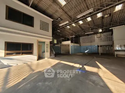 Spacious industrial warehouse with high ceilings and ample natural light.