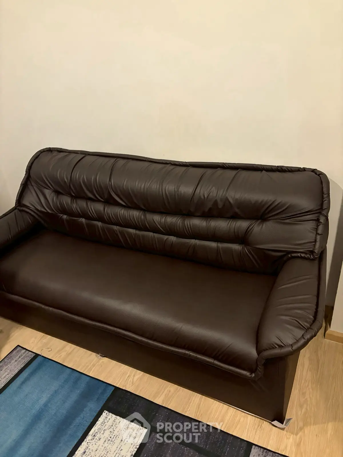 Elegant brown leather sofa in a cozy living room setting with stylish flooring.