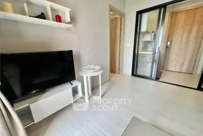 Modern living room with sleek TV setup and stylish decor in a contemporary apartment.