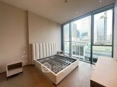 Spacious bedroom with city view and modern furnishings in high-rise apartment