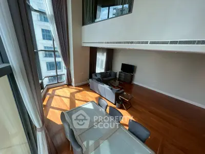 Spacious modern living room with high ceilings and large windows offering abundant natural light.