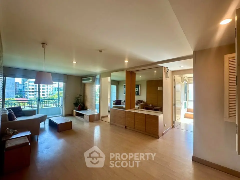 Spacious modern living room with large windows and balcony view in urban apartment.