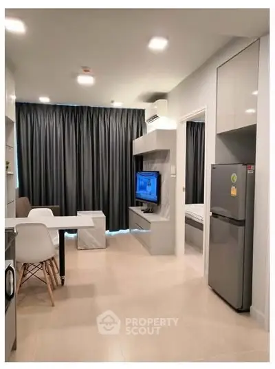 Modern open-plan living room with sleek kitchen and cozy dining area, featuring contemporary furniture and stylish decor.