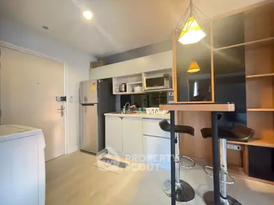 Modern kitchen with sleek design, featuring a breakfast bar and stainless steel appliances.