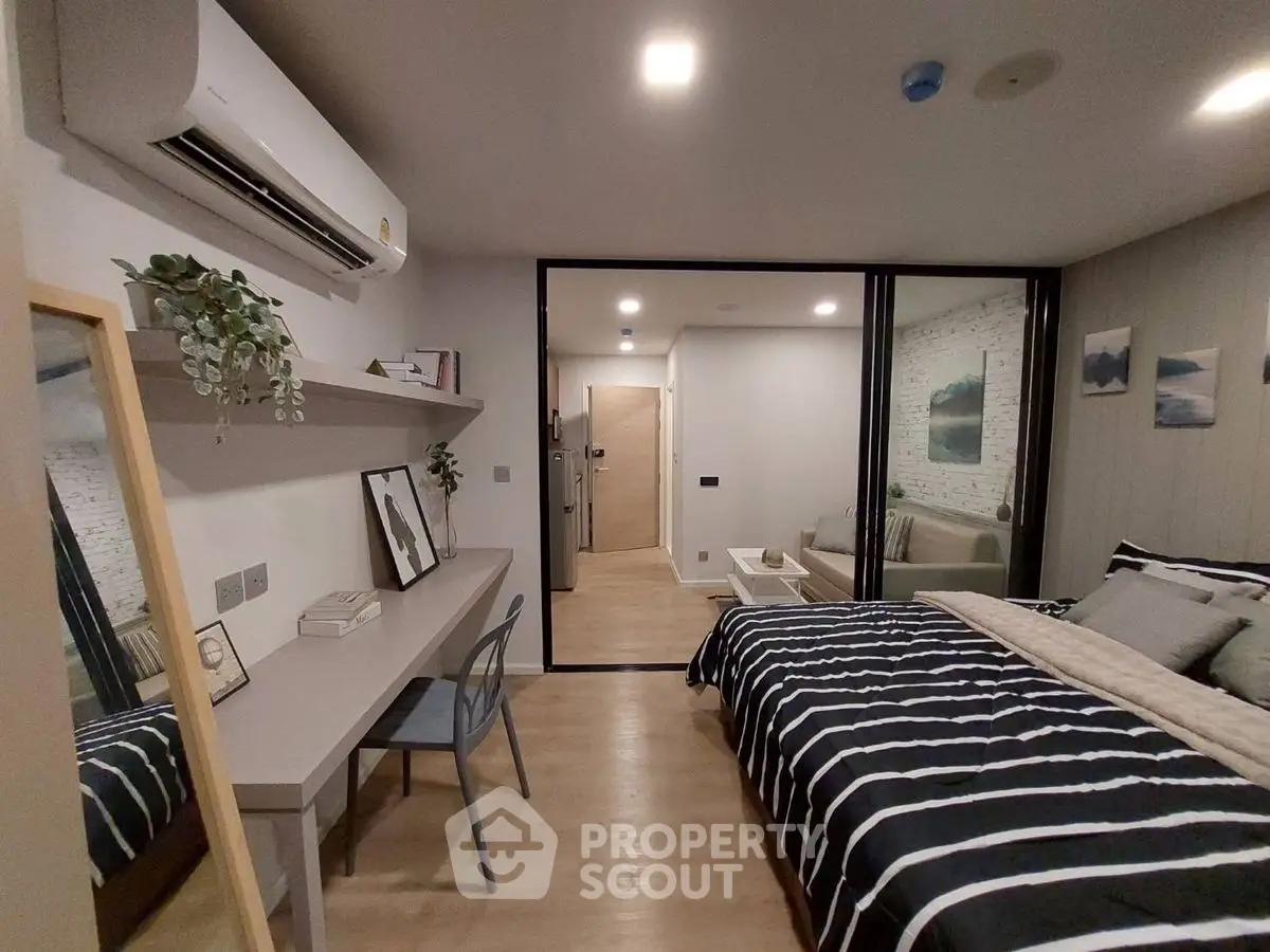 Modern bedroom with stylish decor and workspace in a cozy apartment.