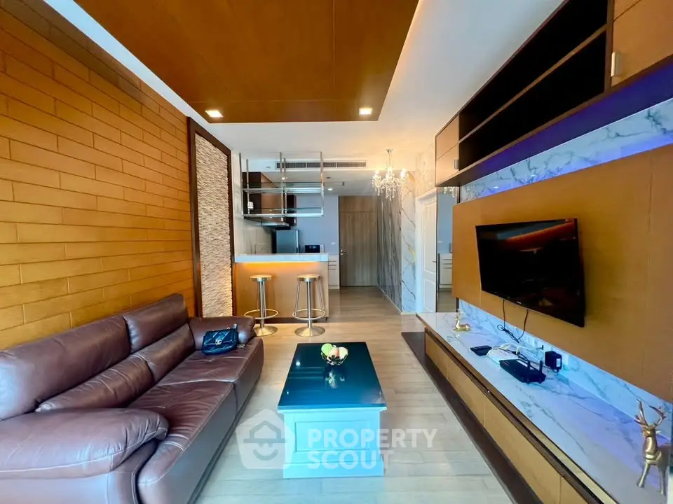 Luxurious modern living room with leather sofa and open kitchen layout, featuring elegant lighting and wood accents.