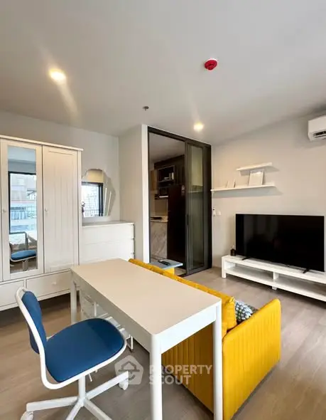 Modern living room with stylish furniture and large TV in a cozy apartment.