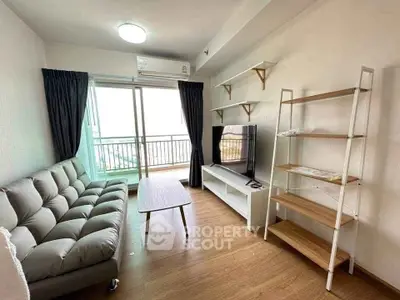 Modern living room with balcony, stylish sofa, and TV unit in a cozy apartment.