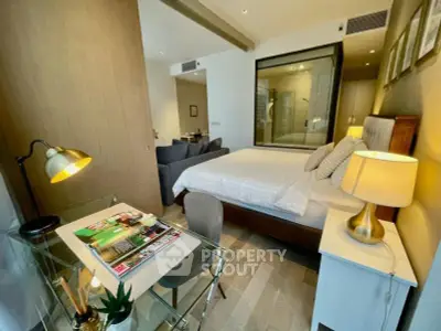 Modern bedroom with glass partition, stylish desk, and cozy lighting in a contemporary apartment.