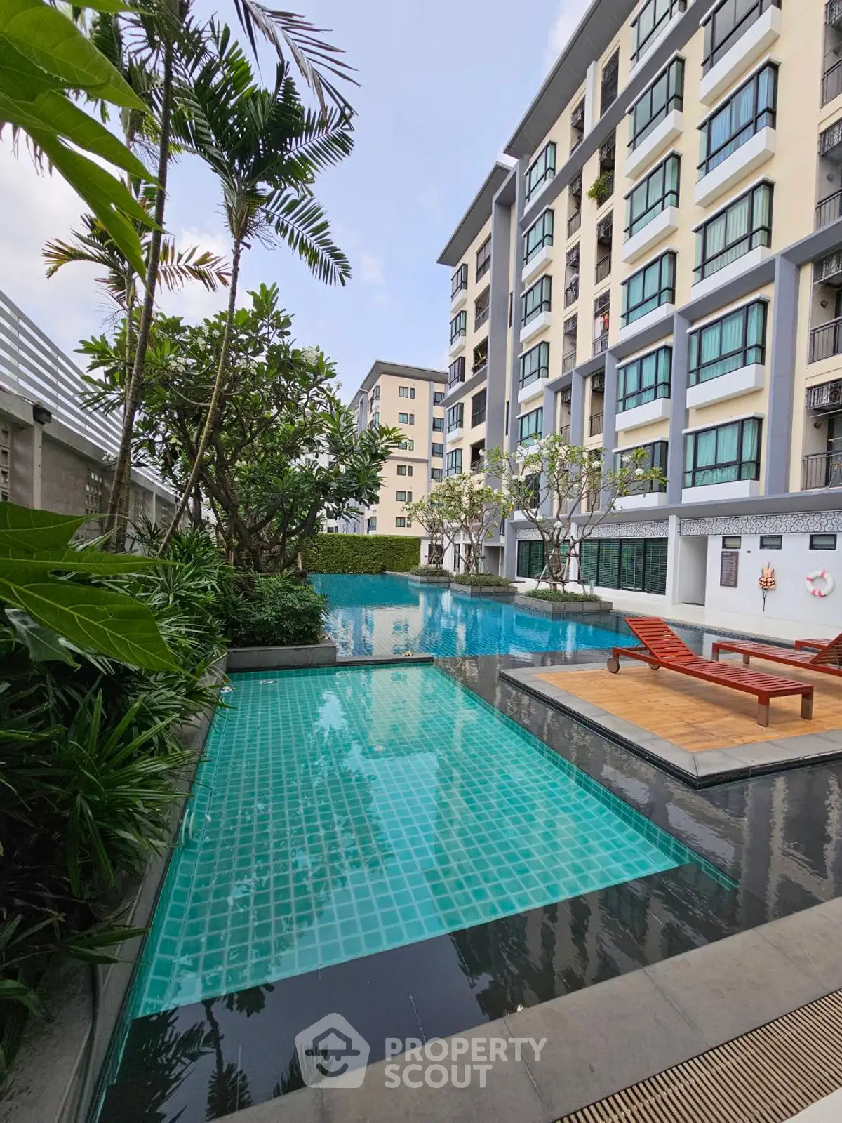 Luxurious apartment complex with stunning pool and lush greenery