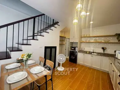 Charming kitchen with dining area and stylish staircase, perfect for modern living.
