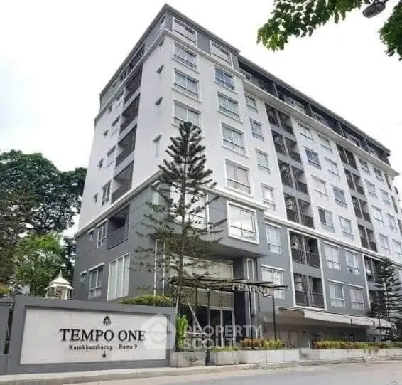 Modern apartment building with sleek design and lush surroundings at Tempo One.